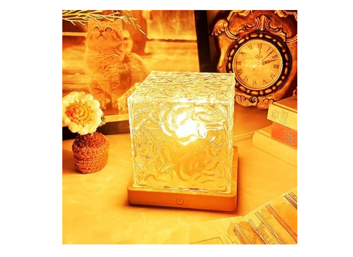 Wave-pattern cube lamp glowing warm yellow in a styled room