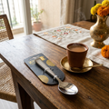SteelFab spoon in packaging on wooden dining table with chai