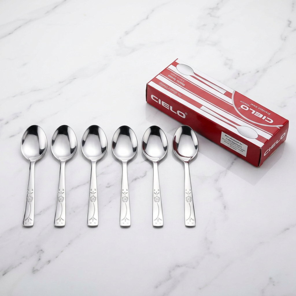 Floral engraved spoons in row with Cielo gift box on marble